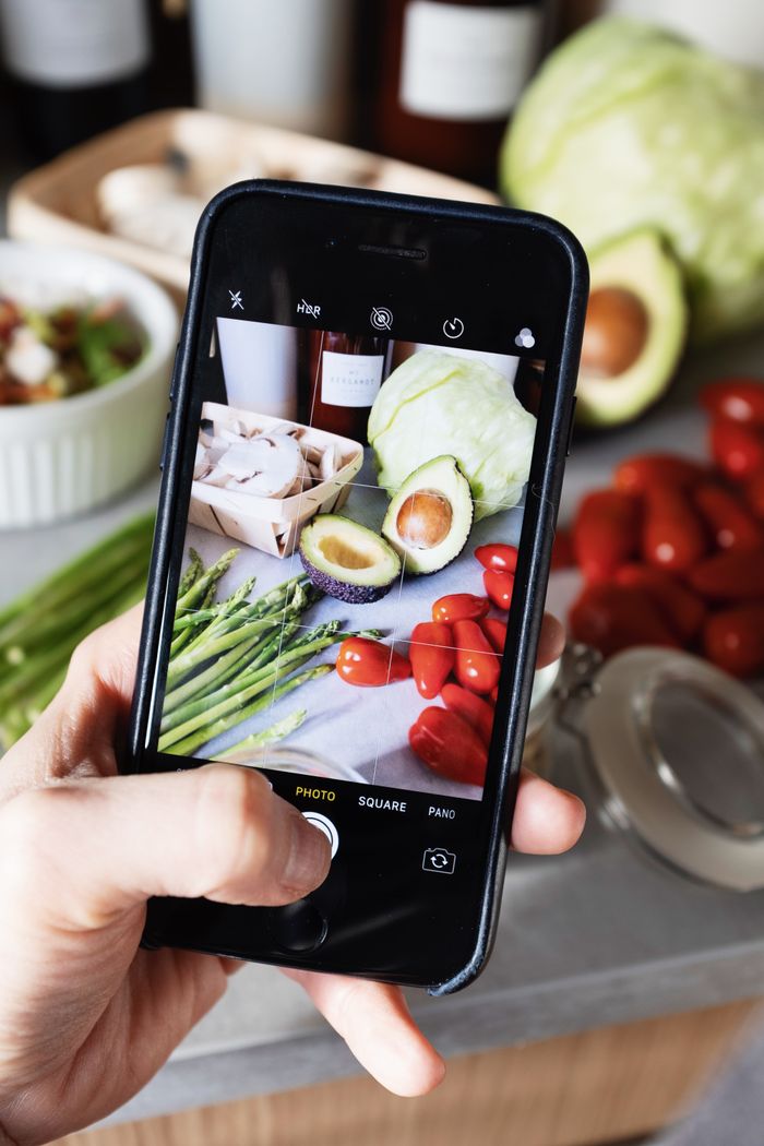 why-choose-us Faceless person taking photo on smartphone of fresh vegetables placed on table in modern light kitchen at home