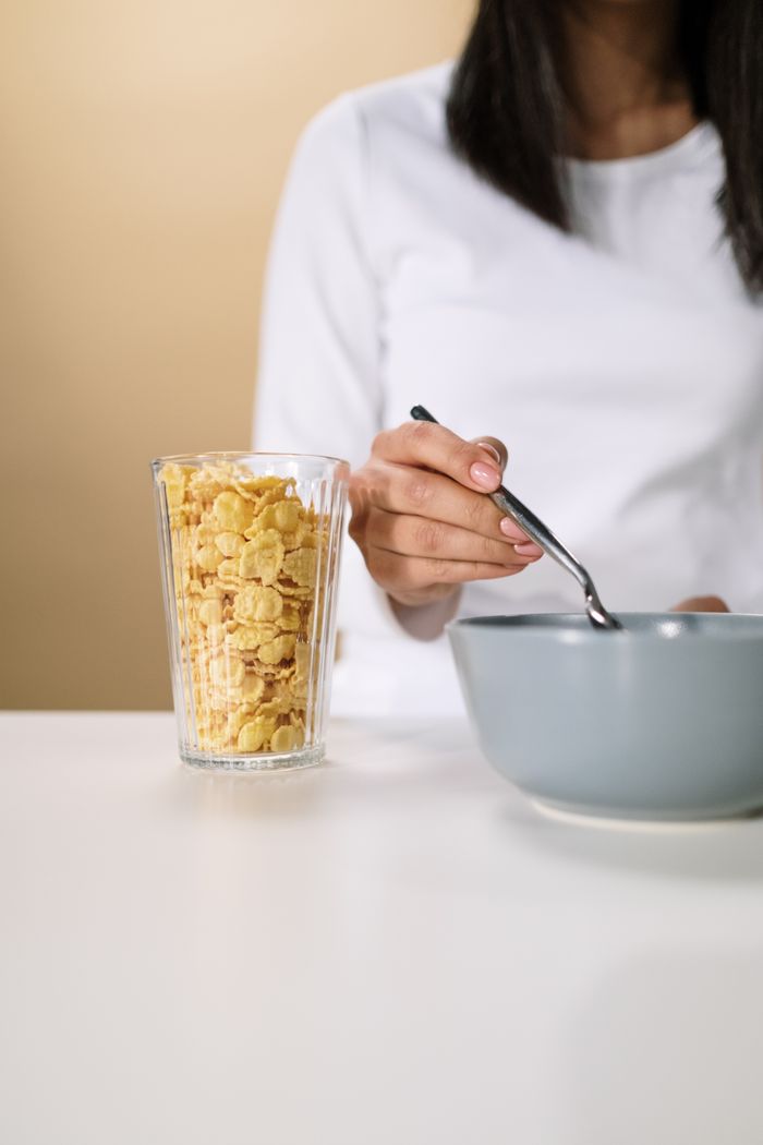 services-02 Close-up of a woman having breakfast with cereal and milk, promoting a healthy lifestyle.