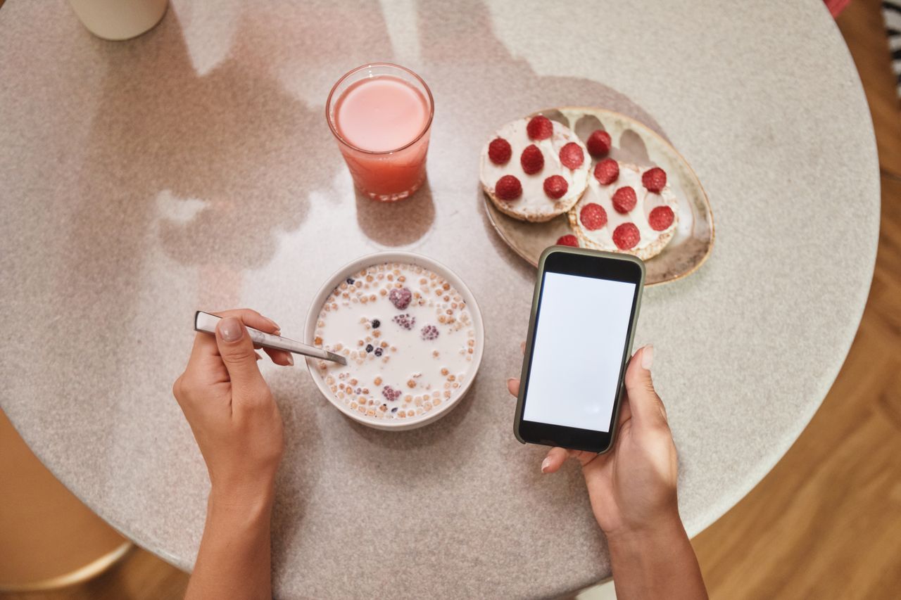 services-02 A cozy breakfast setup with cereal, toast, and a smartphone screen in view.